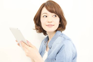 Dijital tablet kullanan gülümseyen Asyalı kadın