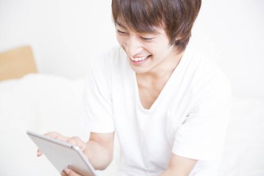 Tablet kullanan Asyalı bir adama yaklaş.