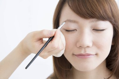 Güzellik salonunda makyaj yapan Asyalı güzel bir kadının yakın çekimi. 