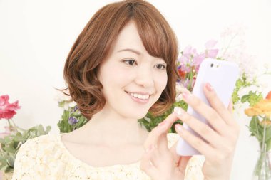 Akıllı telefon kullanan güzel bir Japon genç kadın.