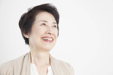 Beyaz kısa saçlı, gülümseyen Asyalı son sınıf öğrencisi.