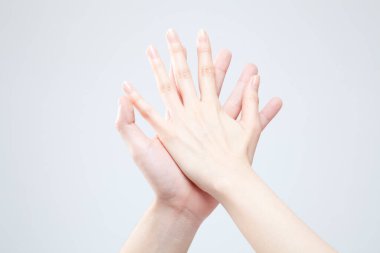 Beyaz arka planda el hareketi yapan kadınların yakın çekimi. 