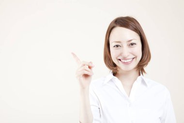 Gülümseyen genç bir kadın fotokopi alanını işaret ediyor