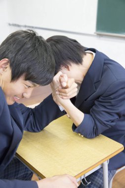 Sınıftaki iki Asyalı öğrencinin bileklerini kesiyorlar.