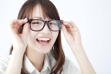 Gözlüklü kadın kameraya gülümsüyor.