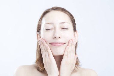 Genç ve güzel bir kız yüzüne dokunuyor