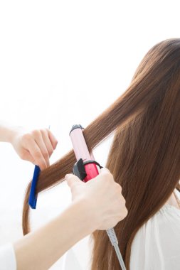 Güzellik salonunda kıvırcık saçlı genç bir kadın.