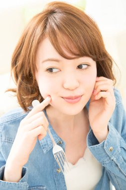 Güzel genç Japon kadının portresi zevkle yemek yiyor.