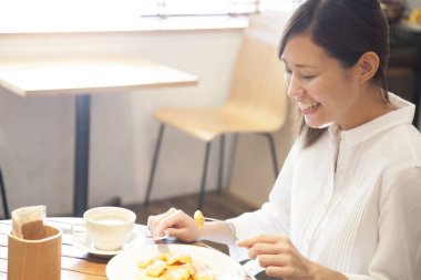 Kafede nefis bir kahvaltı yapan bir kadın. 