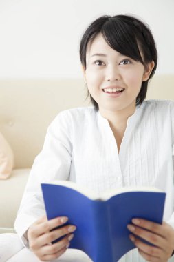 Güzel Asyalı kız evde ders çalışıyor.