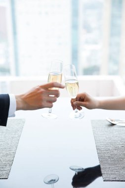 Restoranda şampanya içen genç bir çift.