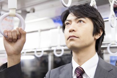 Yetişkin Japon iş adamının portresi metroda çalışacak.