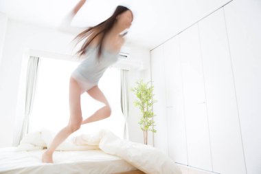 Genç kadın evde yatakta atlama 