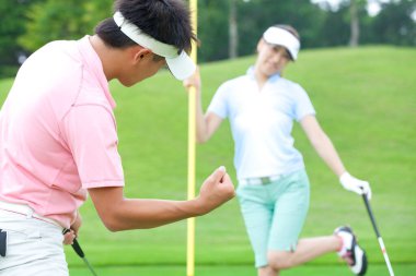 Golf oynayan genç Japon çift.