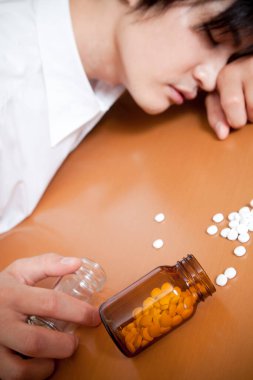 Asyalı adam intihar etmek için bir sürü hap alıyor.