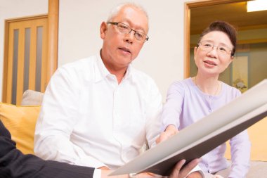 Yaşlı çift içeride belgeleri inceliyor.