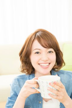 Bir kupa kahveyle güzel bir Asyalı genç bayan.