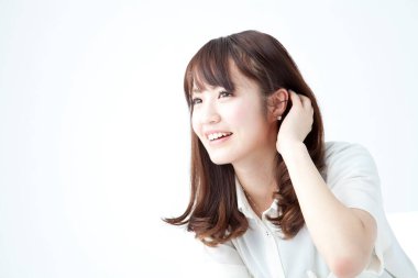 Beyaz arka planda gülümseyen Asyalı bir kadının portresi 