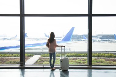 Havaalanı terminalinde bavullu güzel bir Japon kadın. seyahat ve tatil kavramı