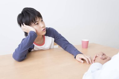 Japon baba ve oğlu evde çay içiyor.