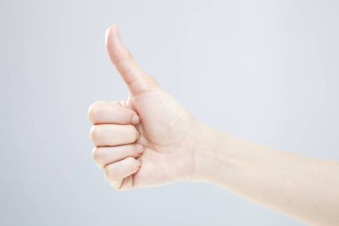 Beyaz arka planda el hareketi yapan kadınların yakın çekimi. 