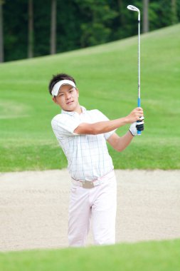 Genç Japon adam gündüz golf oynuyor. 