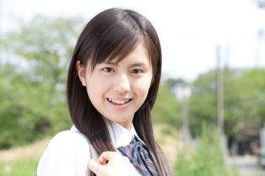 Dışarıda poz veren Asyalı genç bir kadının portresi. 