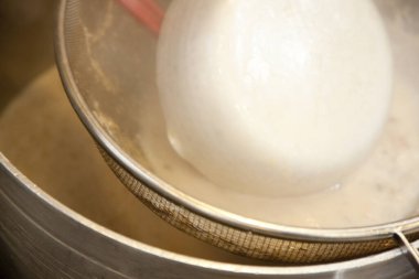 Sıvı kremalı sıvıyı ince metal elekten geçirir.