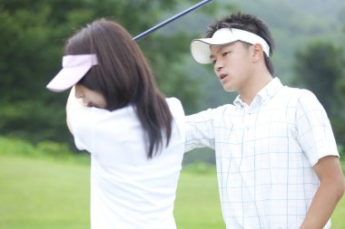 Golf oynayan Asyalı çift.