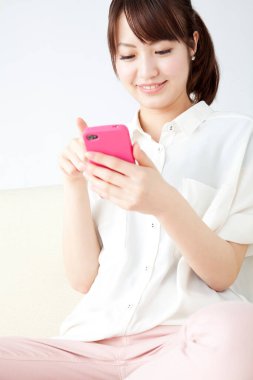 Cep telefonu kullanan Asyalı kadın, stüdyo fotoğrafı. 