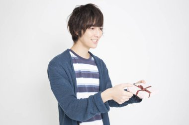 Genç adam hediyesini tutuyor.