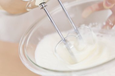 Kremalı hamuru elektrikli el mikseriyle karıştırıyorum.