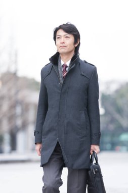 Asyalı işadamı şehirde yürüyor