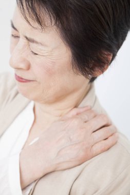 Omzunda ağrı olan yaşlı Asyalı kadın. 