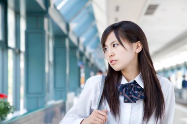 Üniversite kampüsündeki Asyalı kadın öğrenci.