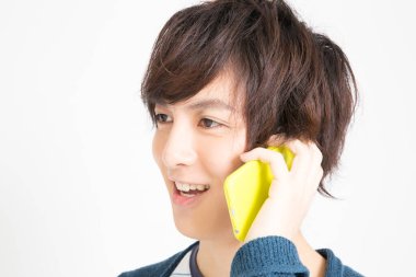 Cep telefonlu genç Asyalı, stüdyo fotoğrafı. 