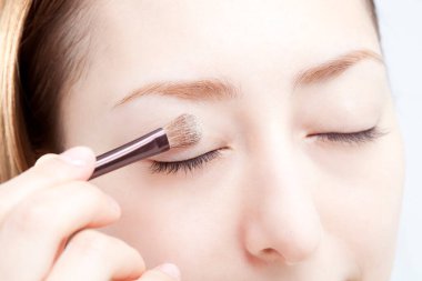 Güzel kız makyaj yapıyor.