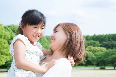 Anne ve kızı parkla oynuyor.