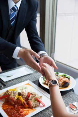 Restoran masasında kadının elini tutan adam.