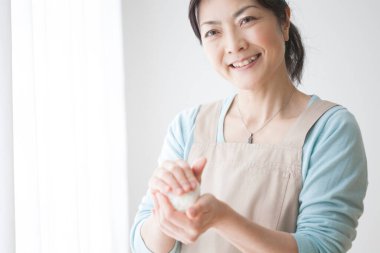 Asyalı kadın pirinçli onigiri yapıyor.