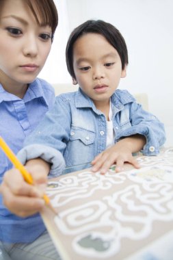 Asyalı anne ve oğul ödev yapıyor.