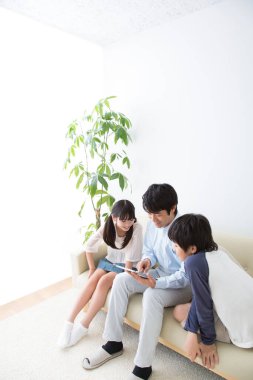 Üç kişilik genç bir aile tablet kullanıyor.