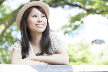 Güzel gülümseyen Asyalı kadın sokakta poz veriyor.