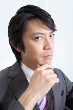 Beyaz takım elbiseli Japon işadamının portresi.