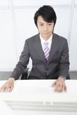 Ofiste çalışan kendinden emin genç Japon işadamı.