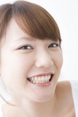 Beyaz arka planda gülümseyen Asyalı kadın