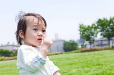 Küçük sevimli Japon çocuk yaz parkında oynuyor.