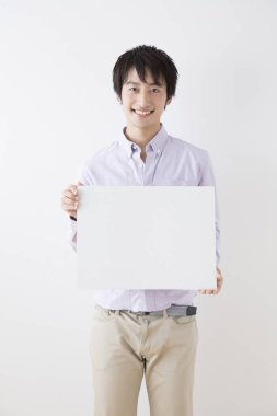 Beyaz tahtası olan Asyalı genç adam.