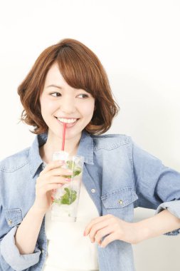 Güzel Japon kadın naneli ferahlatıcı soğuk içecek içiyor.