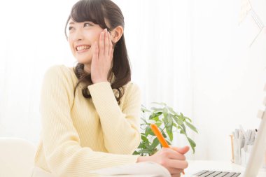 Evde bilgisayarla çalışan genç bir kadın.